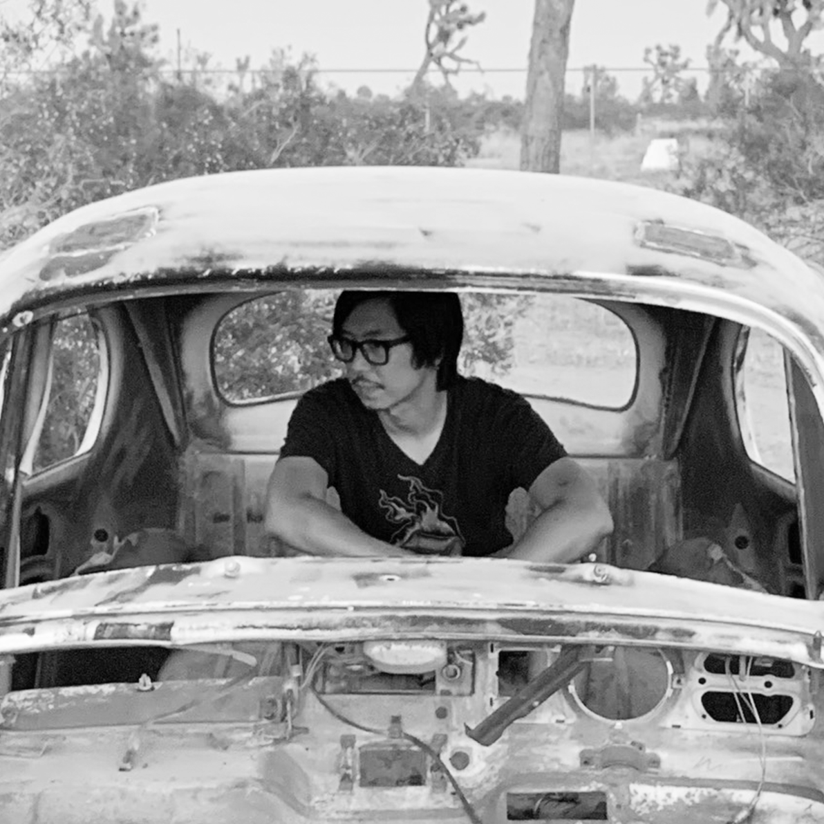 Jeremy poses inside a broken down car