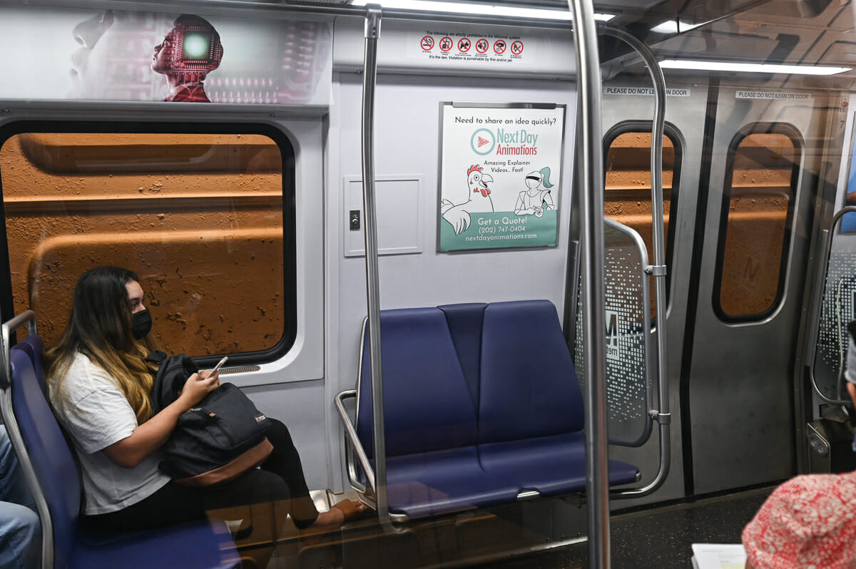 a picture of the inside of a subway car; a Next Day Animations advertisement can be seen